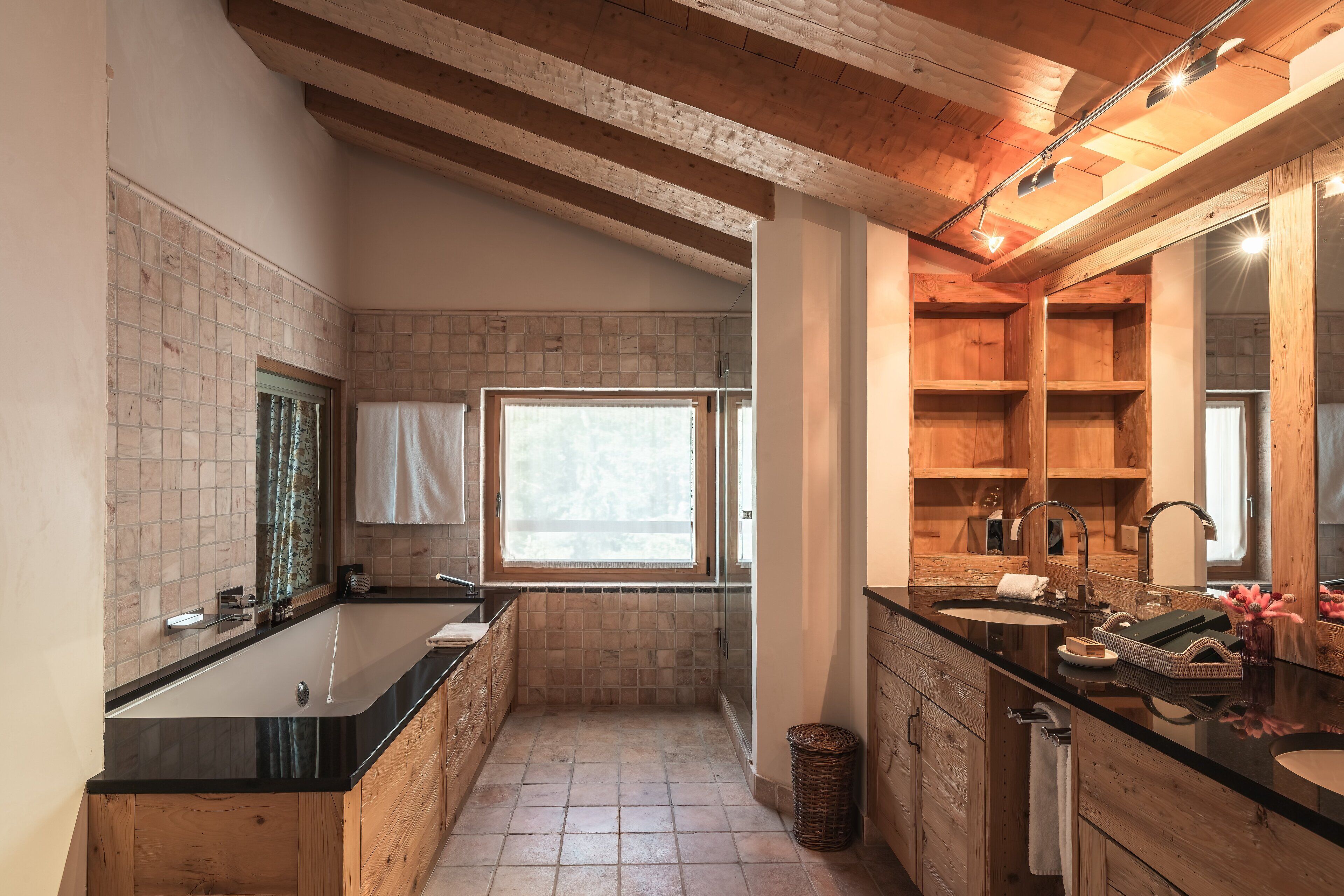 Un baño moderno con una bañera grande, un lavabo independiente y un tocador con espejo.