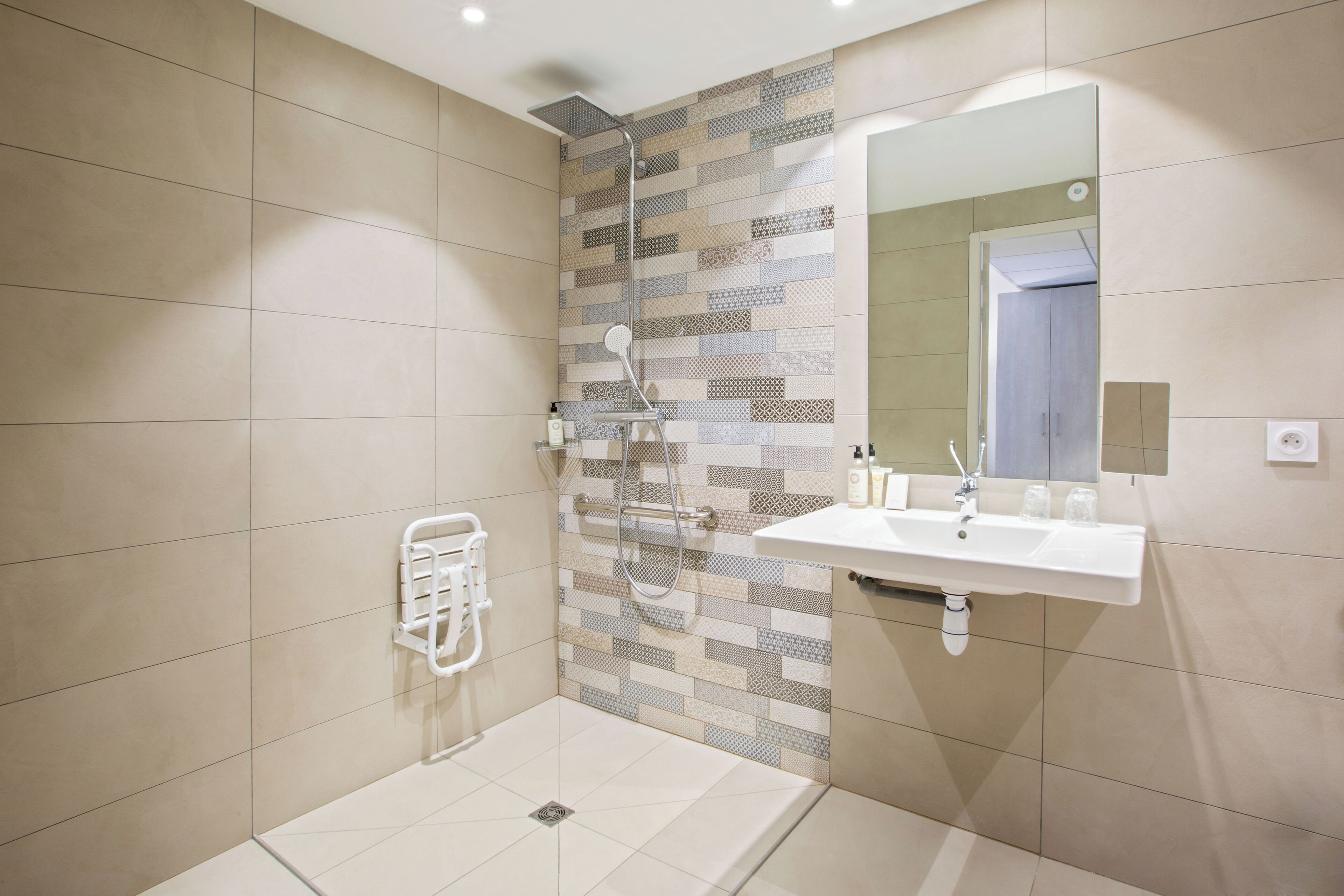 A modern bathroom with a shower, a sink, and a mirror.