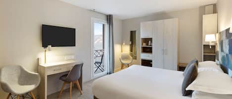 A hotel room with a bed, desk, chair, TV, wardrobe, and a balcony with a view.