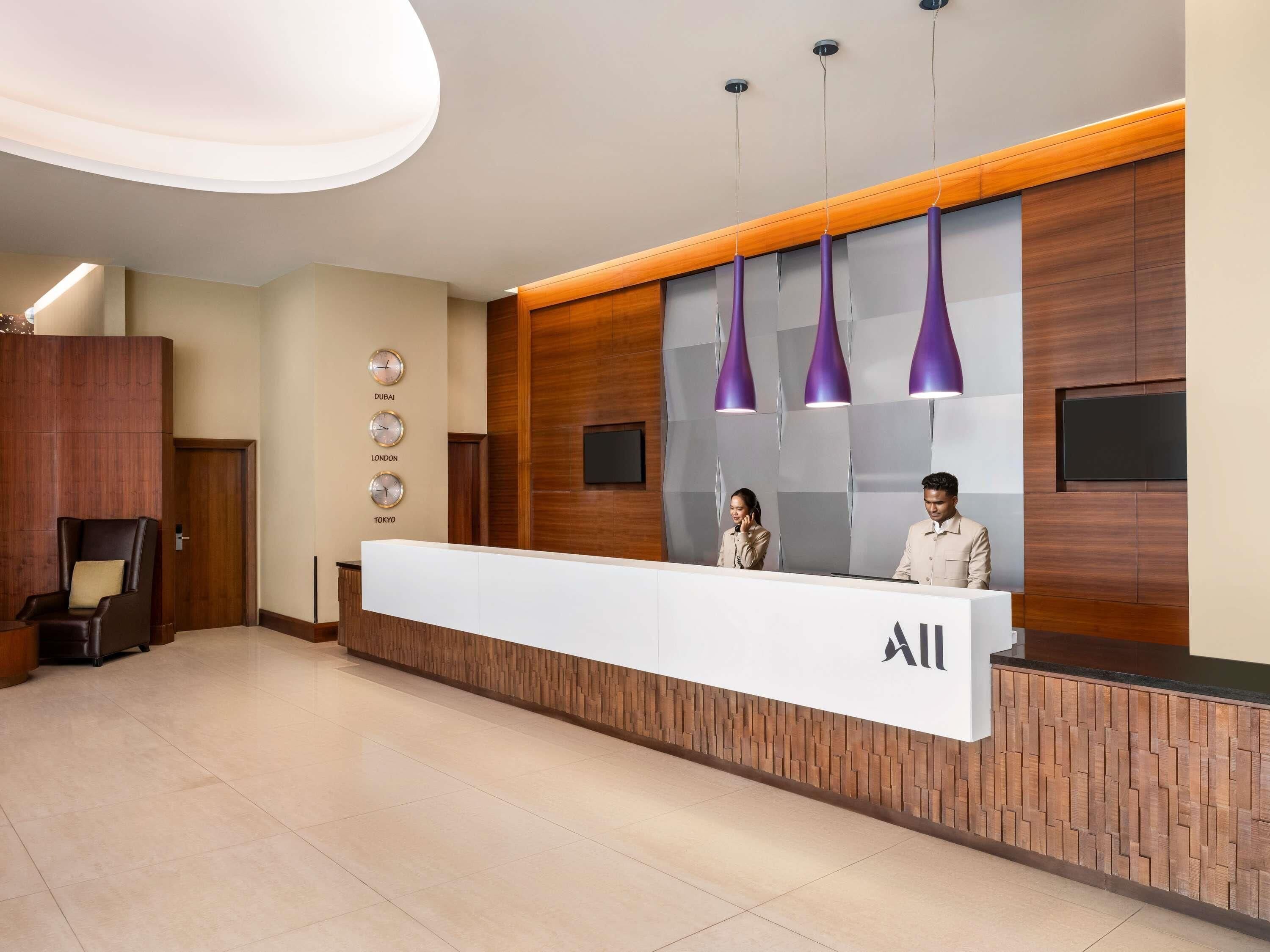 A reception desk with a modern design, including a clock displaying time in Dubai, London, and Tokyo.