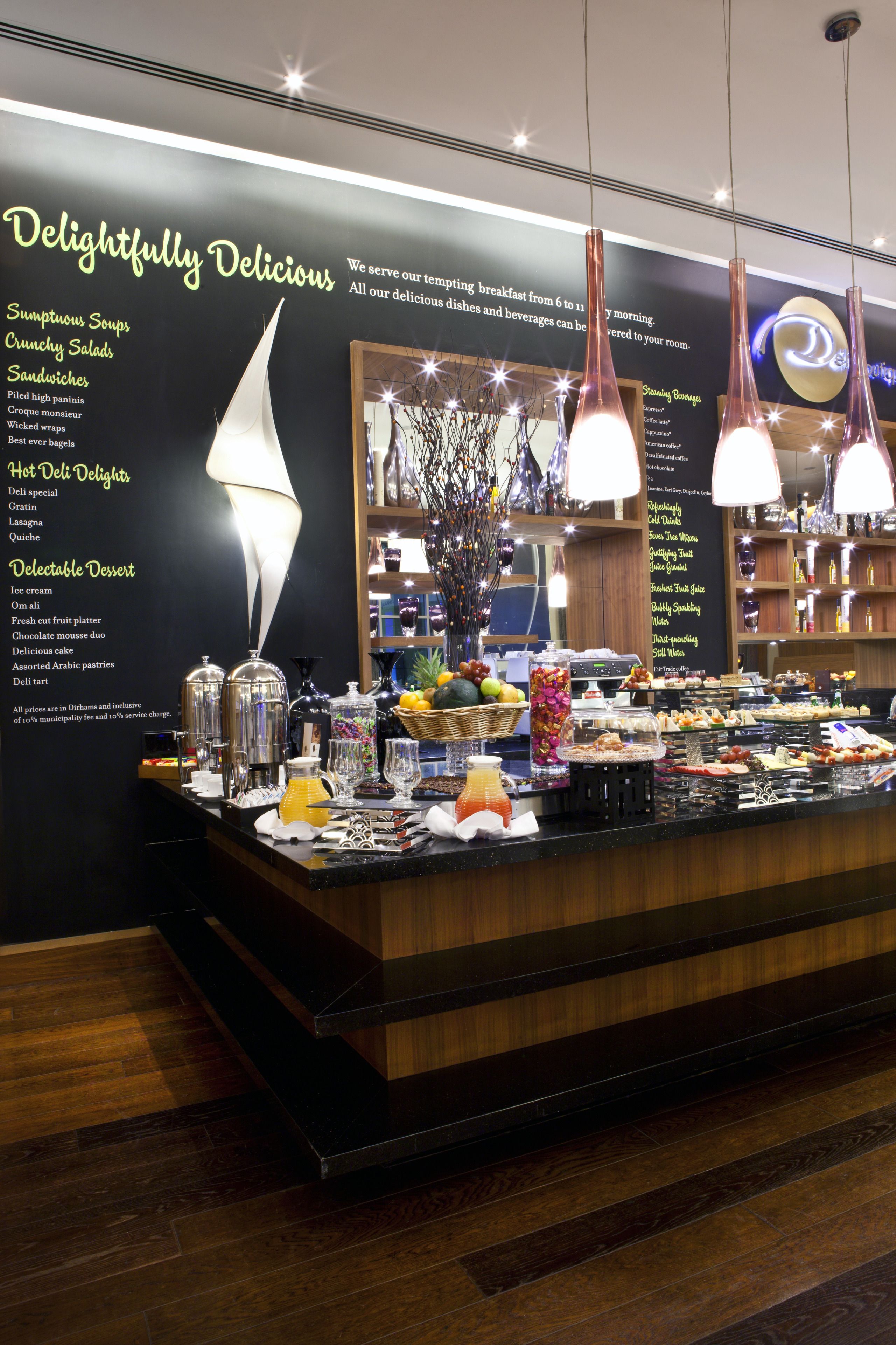 A breakfast buffet with a variety of food options including soups, salads, sandwiches, and desserts.