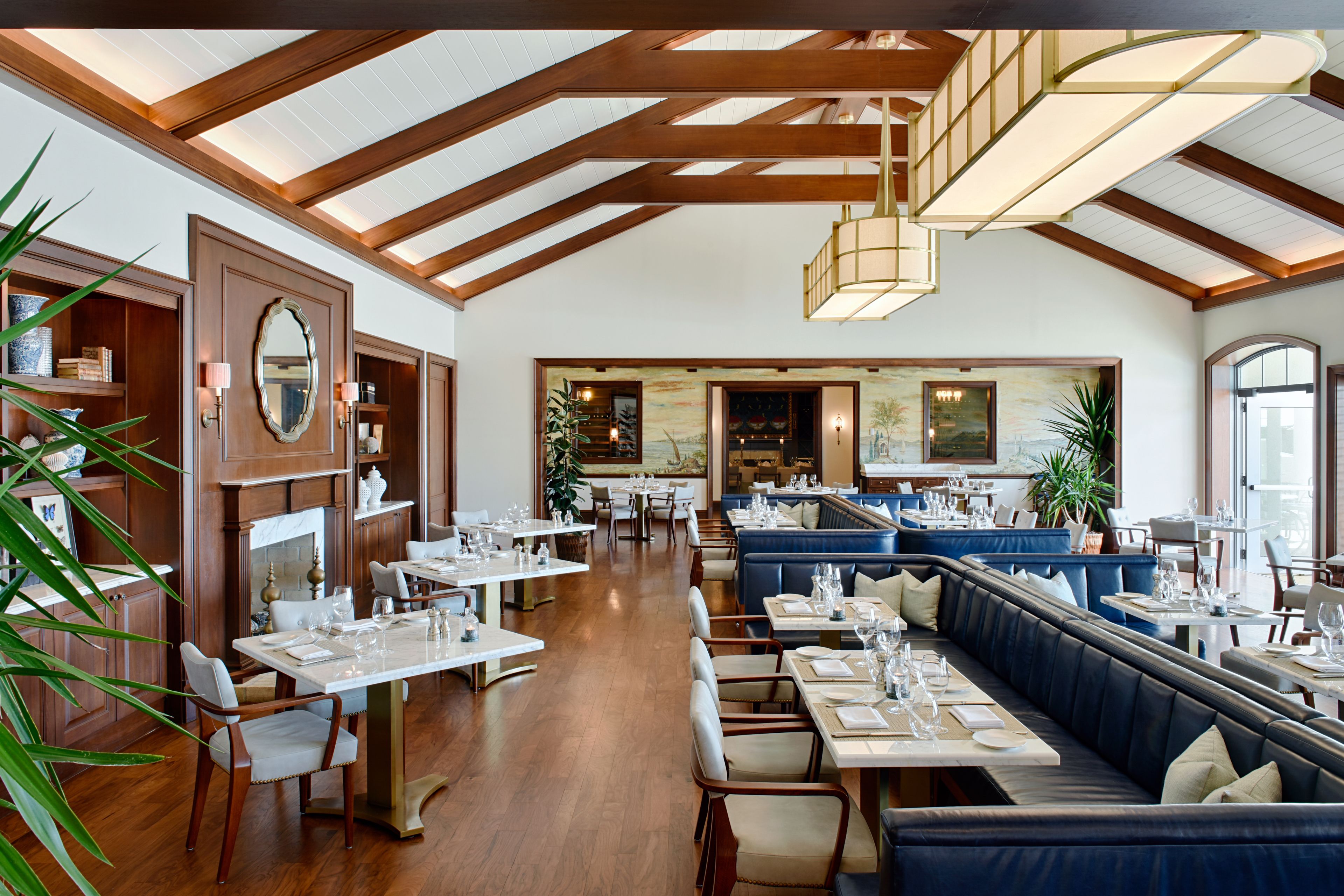 A spacious restaurant with high ceilings, wooden beams, and a mix of tables and booths.