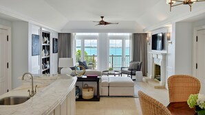 Un interior moderno con cocina, comedor y sala de estar, destacando un ventanal con vistas al mar.