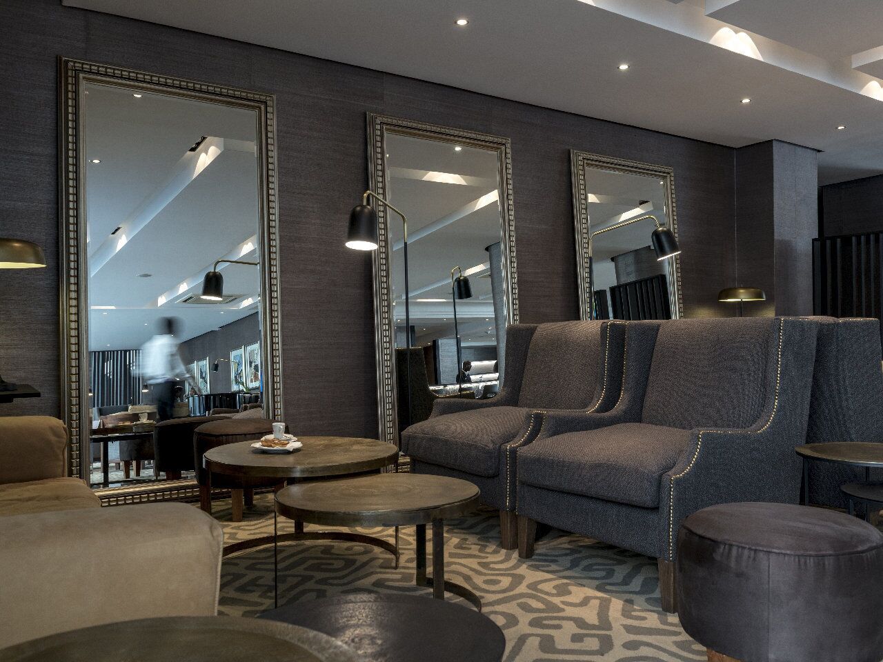 Een moderne zithoek met een bank, fauteuils en een salontafel.