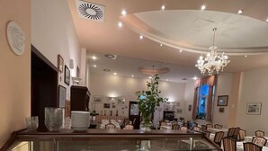 A buffet area with a variety of food items and a seating area with chairs and tables. - Hotel San Marco (Lannach)