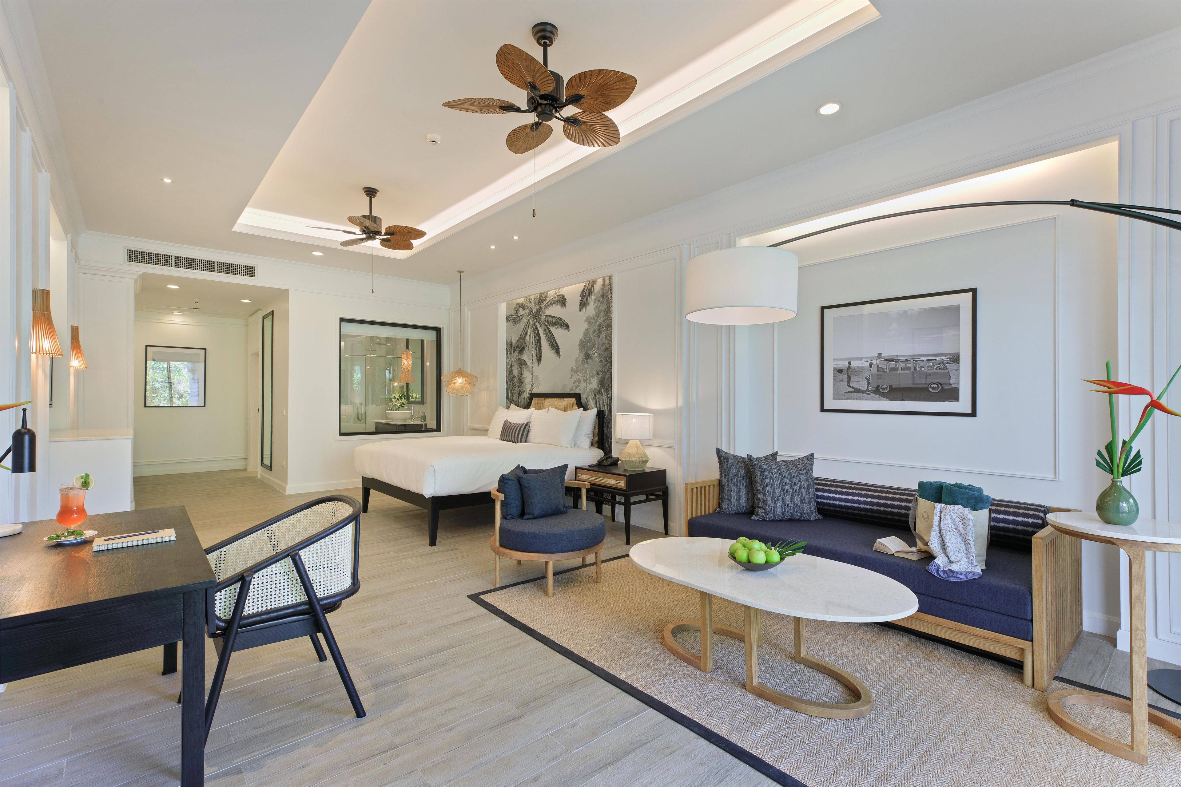 A modern living room with a sofa, coffee table, and a dining area with a table and chairs.