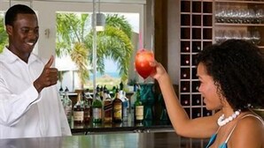 A bar area with a counter, various bottles, and a decorative backdrop.