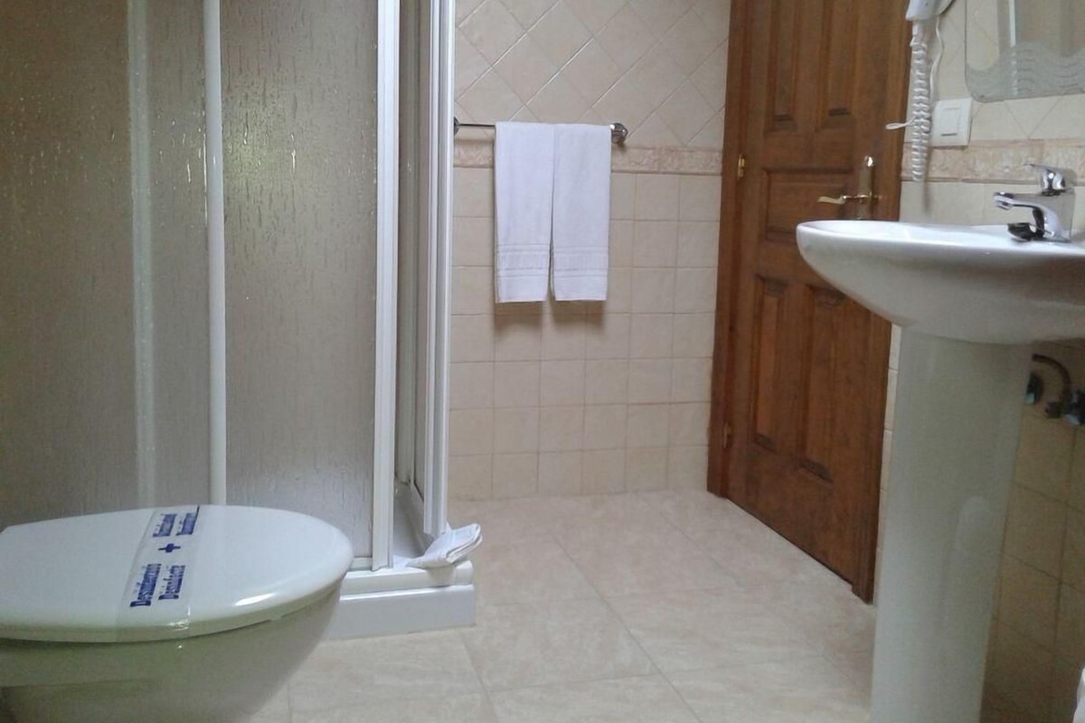Un baño con inodoro, ducha y lavamanos.