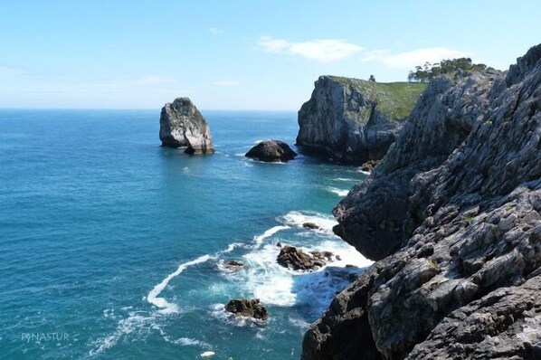 Un paisaje costero con acantilados rocosos y mar azul cristalino.