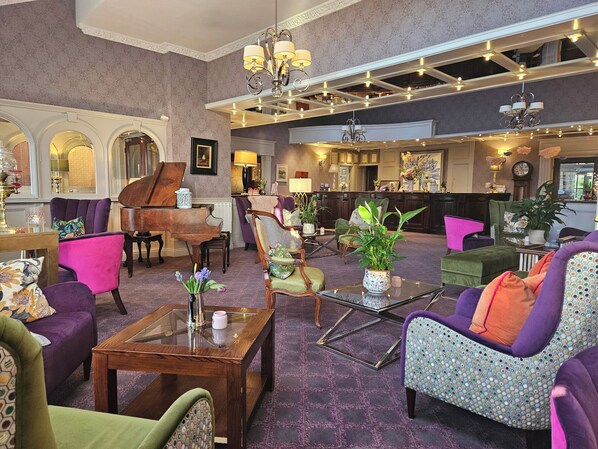 A spacious lobby with a grand piano, comfortable seating, and a reception area. - Whitford House Hotel (Wexford)
