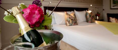 Una cama con sábanas blancas y un cojín decorativo.