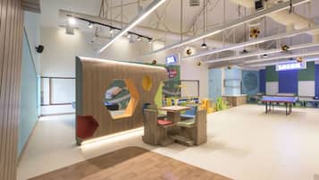 Relax and play in this vibrant space with a variety of seating areas, a ping pong table, and a wooden play area.