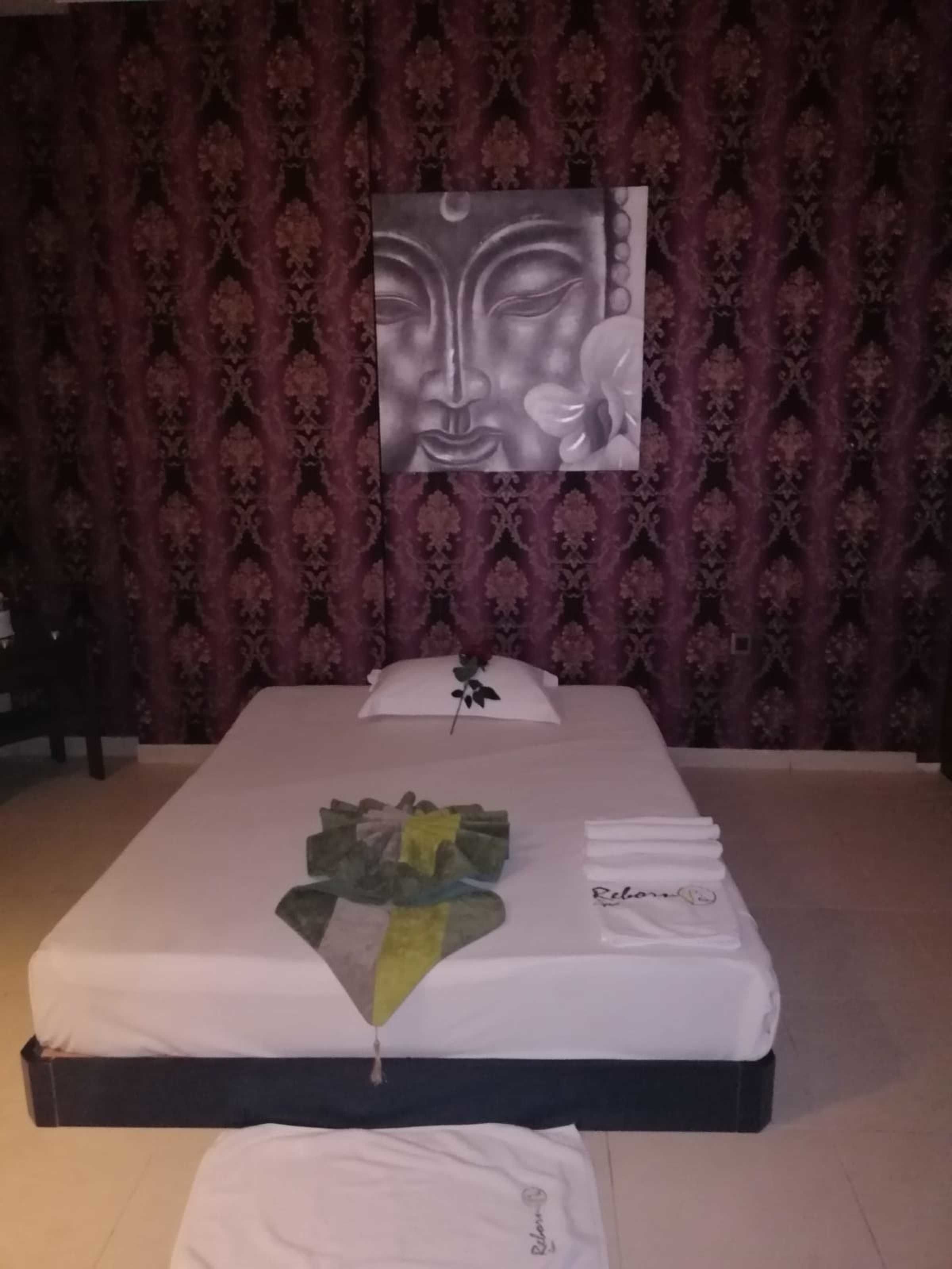 Una cama bien hecha con un almohadón blanco y un adorno en la cabecera.