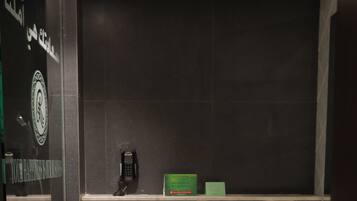 A modern bathroom with a toilet, bidet, and a small trash bin.