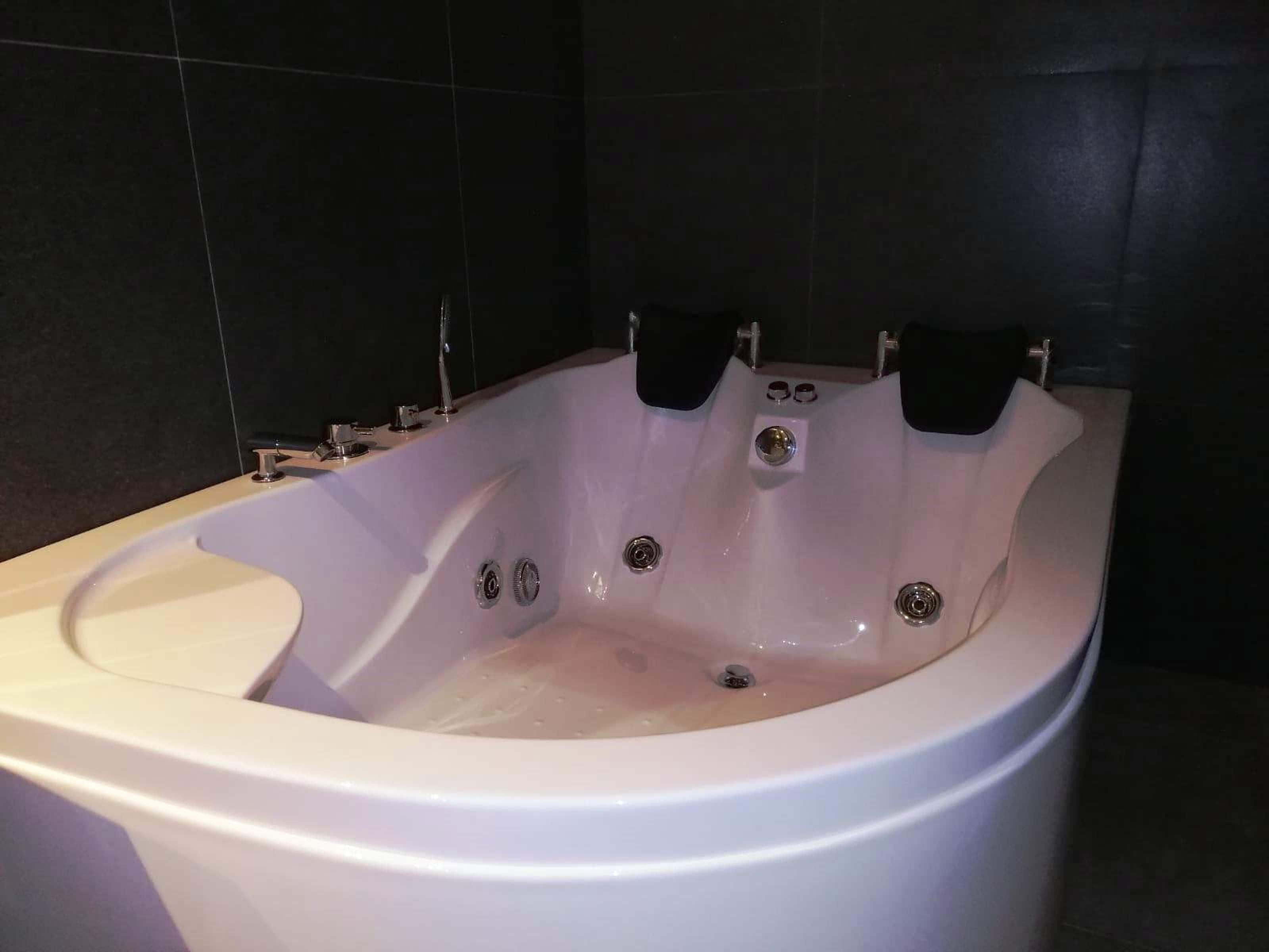 A modern bathroom with a large, freestanding bathtub.