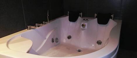 A modern bathroom with a large, freestanding bathtub.