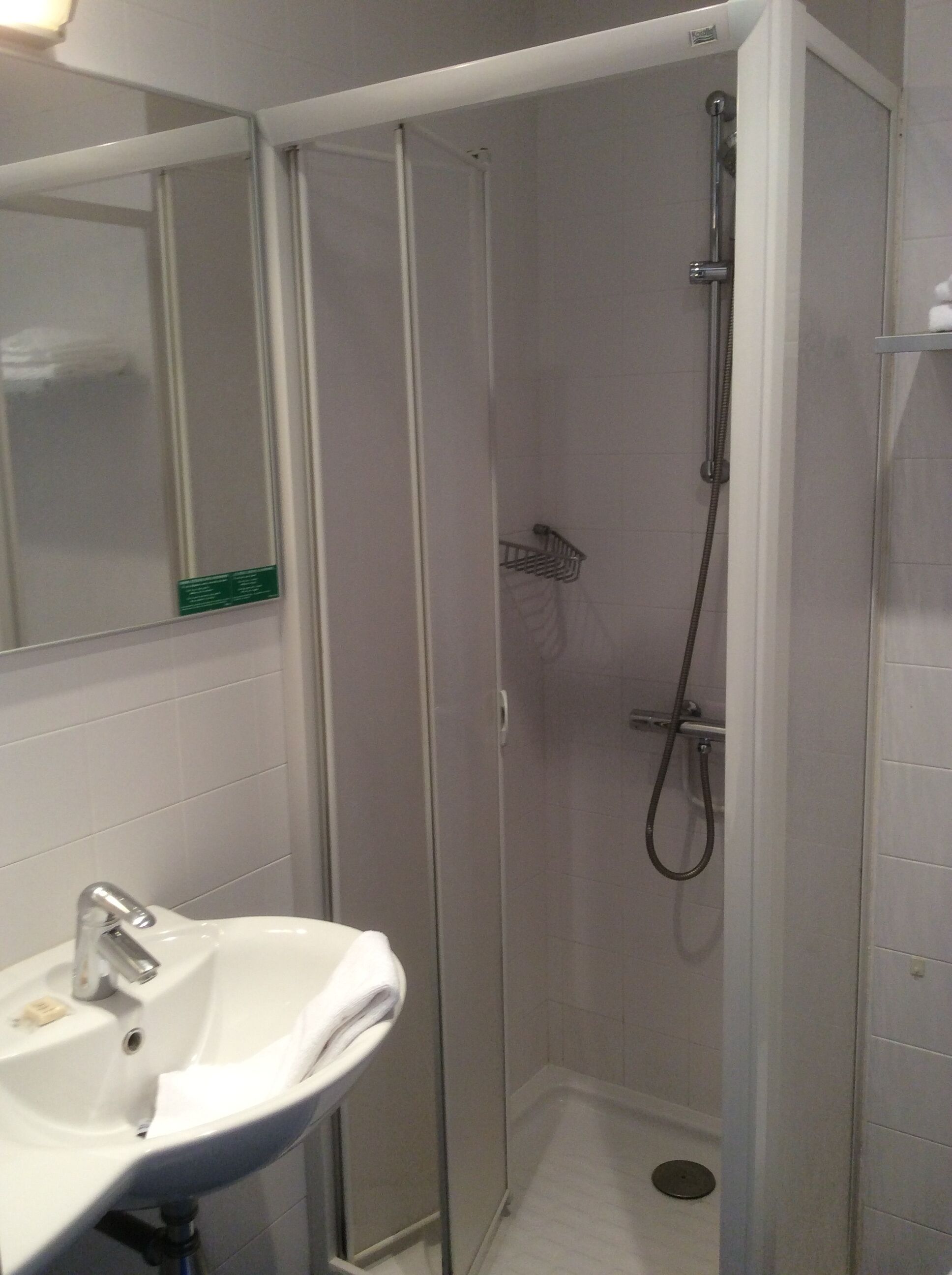Ein Badezimmer mit Dusche, Waschbecken und Spiegel.