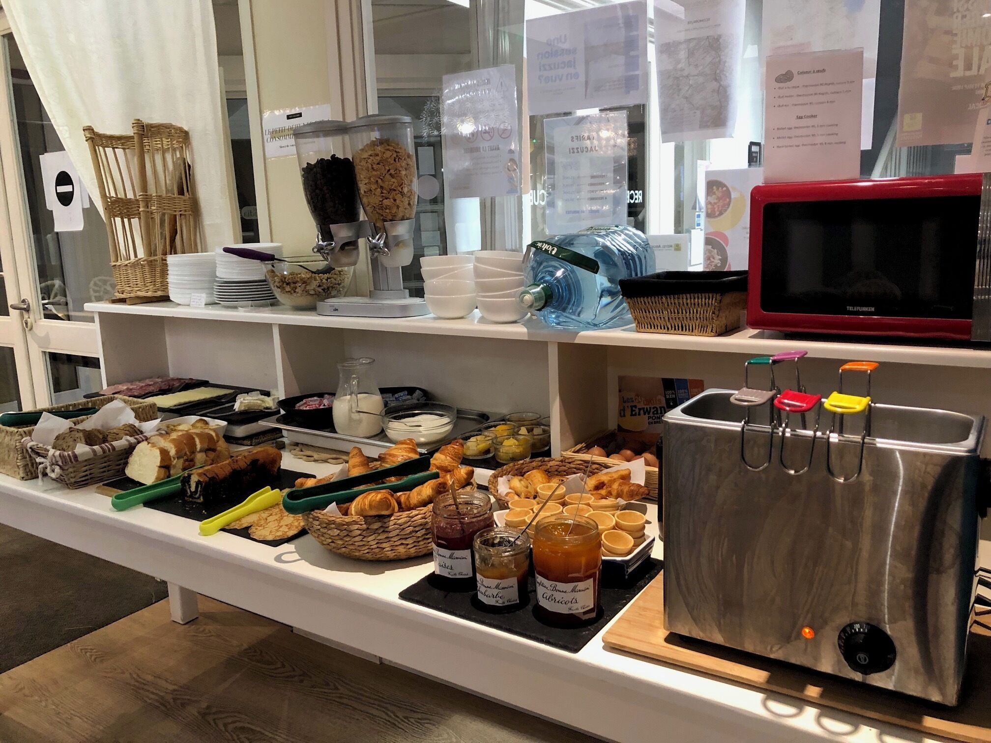Un buffet proposant une variété de plats, notamment du pain, des pâtisseries et des condiments.