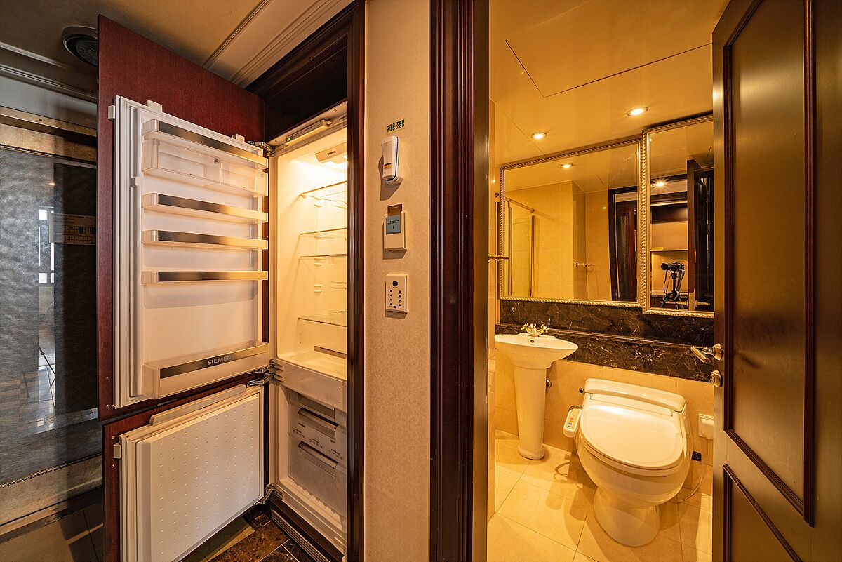 A compact bathroom with a toilet, sink, and a mirror.