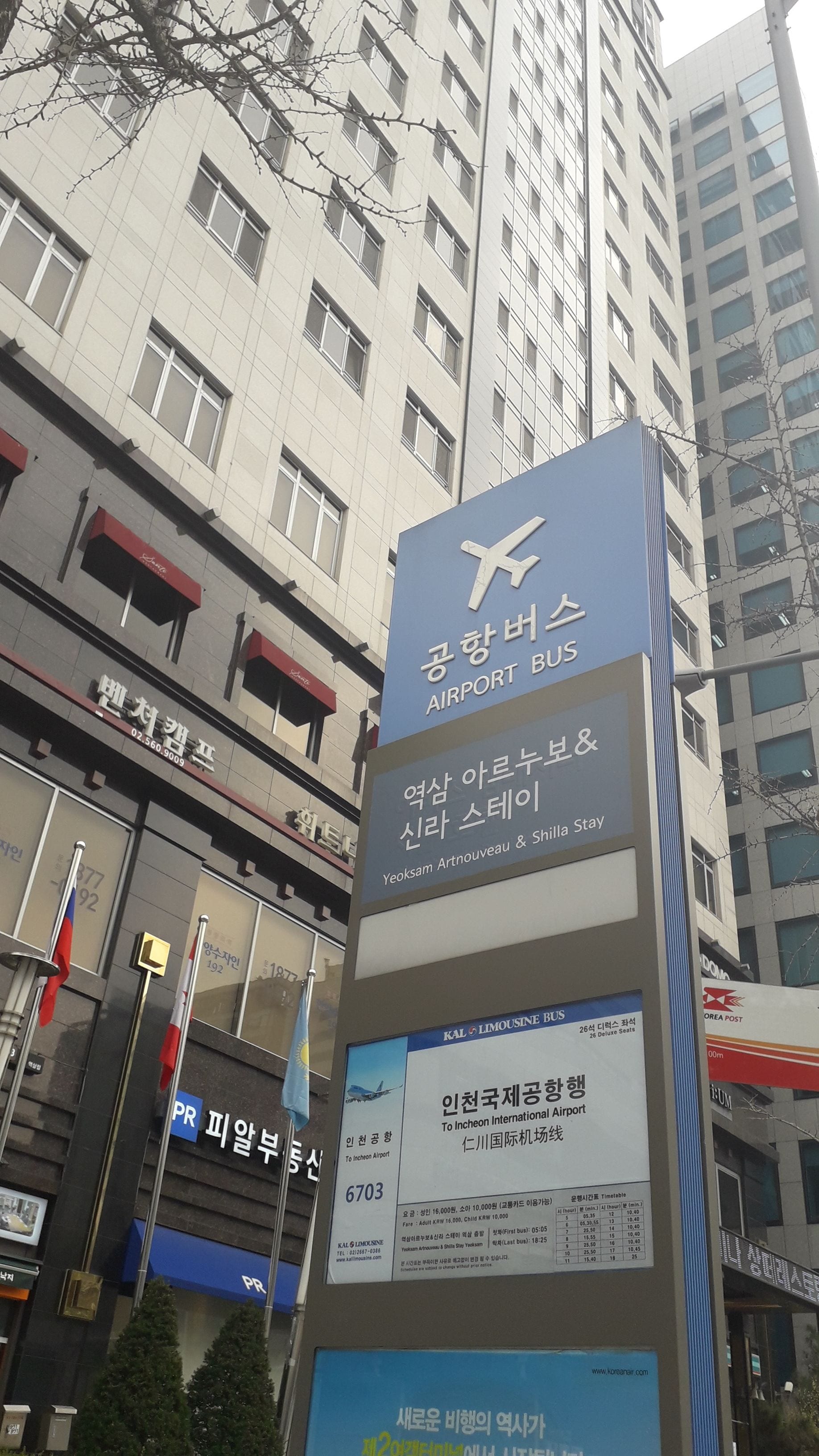 A sign for an airport bus service with a timetable and contact information.