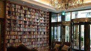 Una biblioteca con estanterías, un candelabro y una zona de estar.