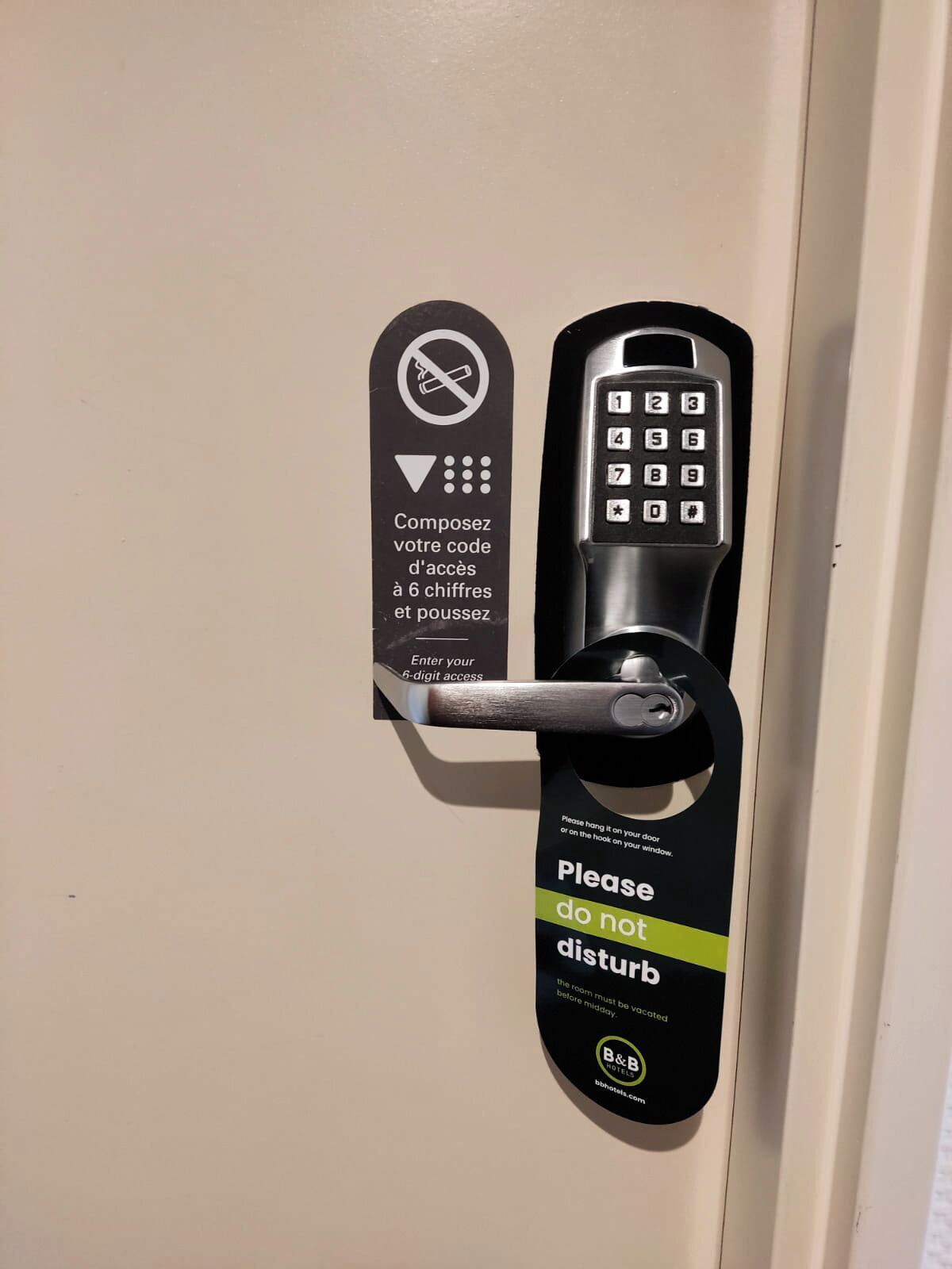 Une porte de chambre d’hôtel dotée d’un clavier à code d’accès à 6 chiffres et d’une indication invitant à l’accrocher au crochet de la porte ou de la fenêtre.