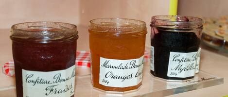Three jars of marmalade on a shelf.