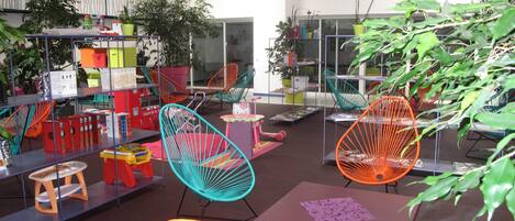 A library with colorful chairs, bookshelves, and potted plants.