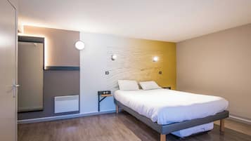 Een moderne slaapkamer met een bed, een nachtkastje, een wandheater en een spiegel.
