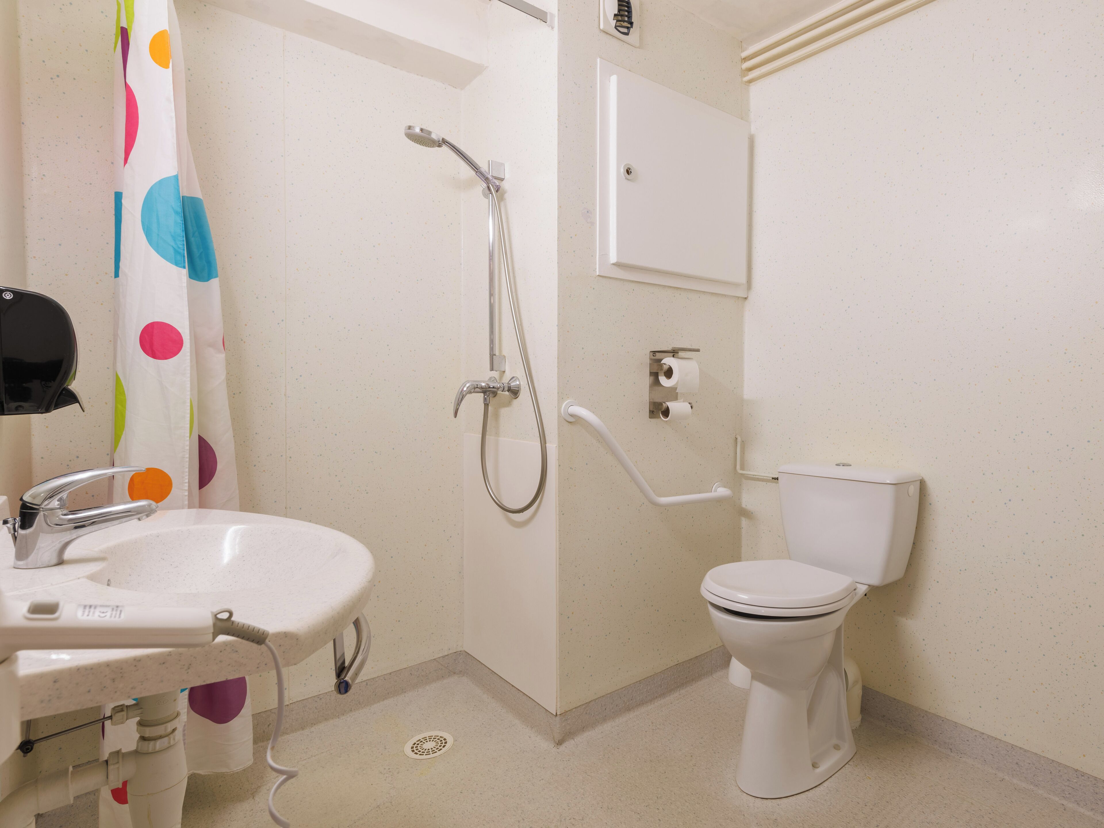 A bathroom with a white sink, toilet, and shower.
