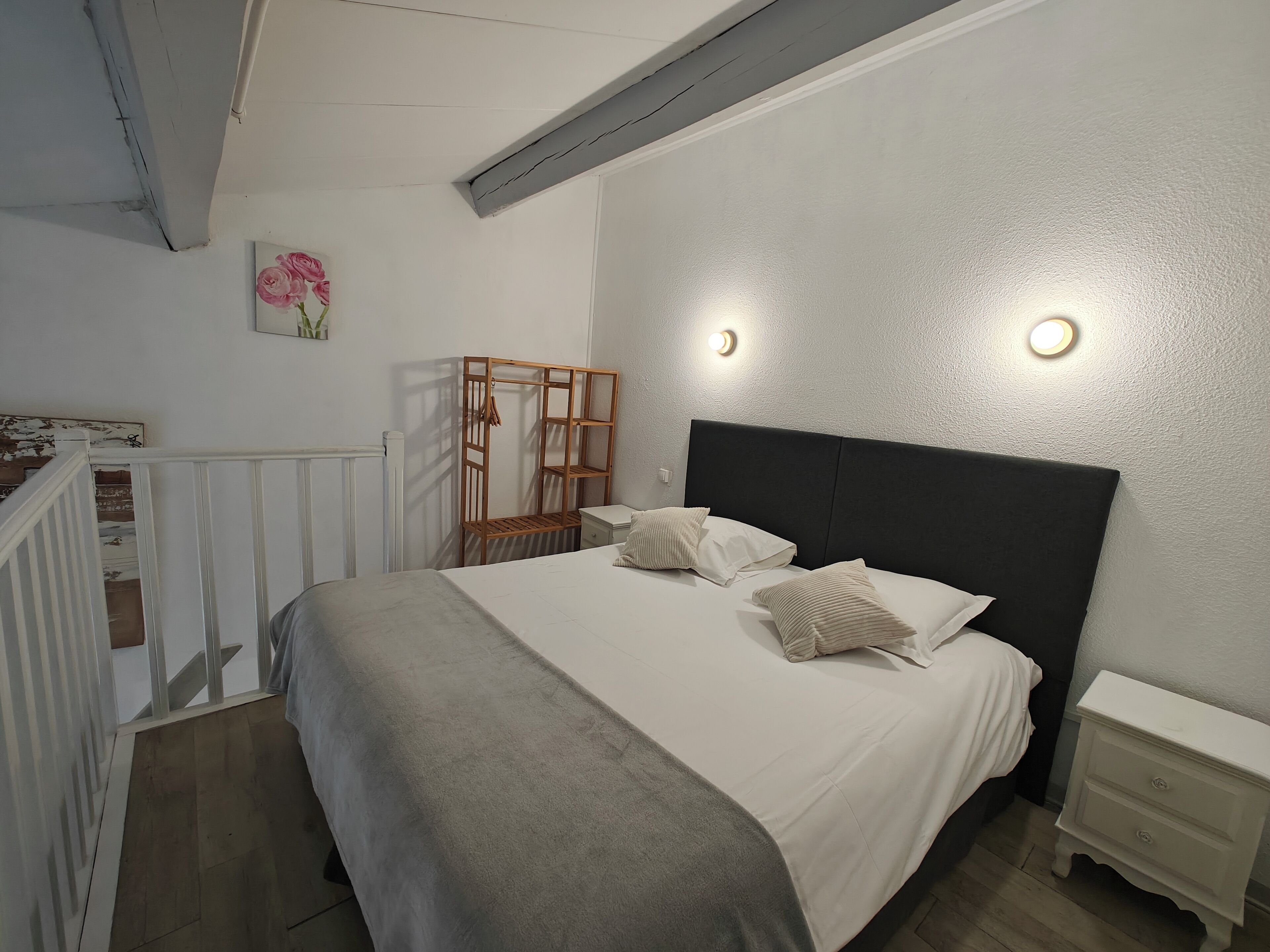Un dormitorio con cama, mesitas de noche, un armario de madera y un radiador.
