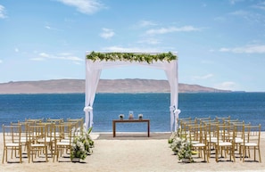 A beach wedding setup with a white arch and chairs. - The Legend Paracas Resort, a Destination by Hyatt Hotel (Paracas)