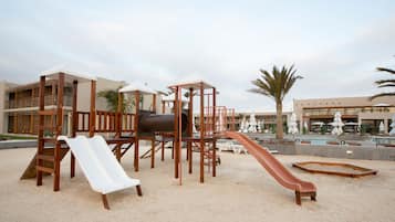 Kids can play on the outdoor play structure with slides and climbing elements.