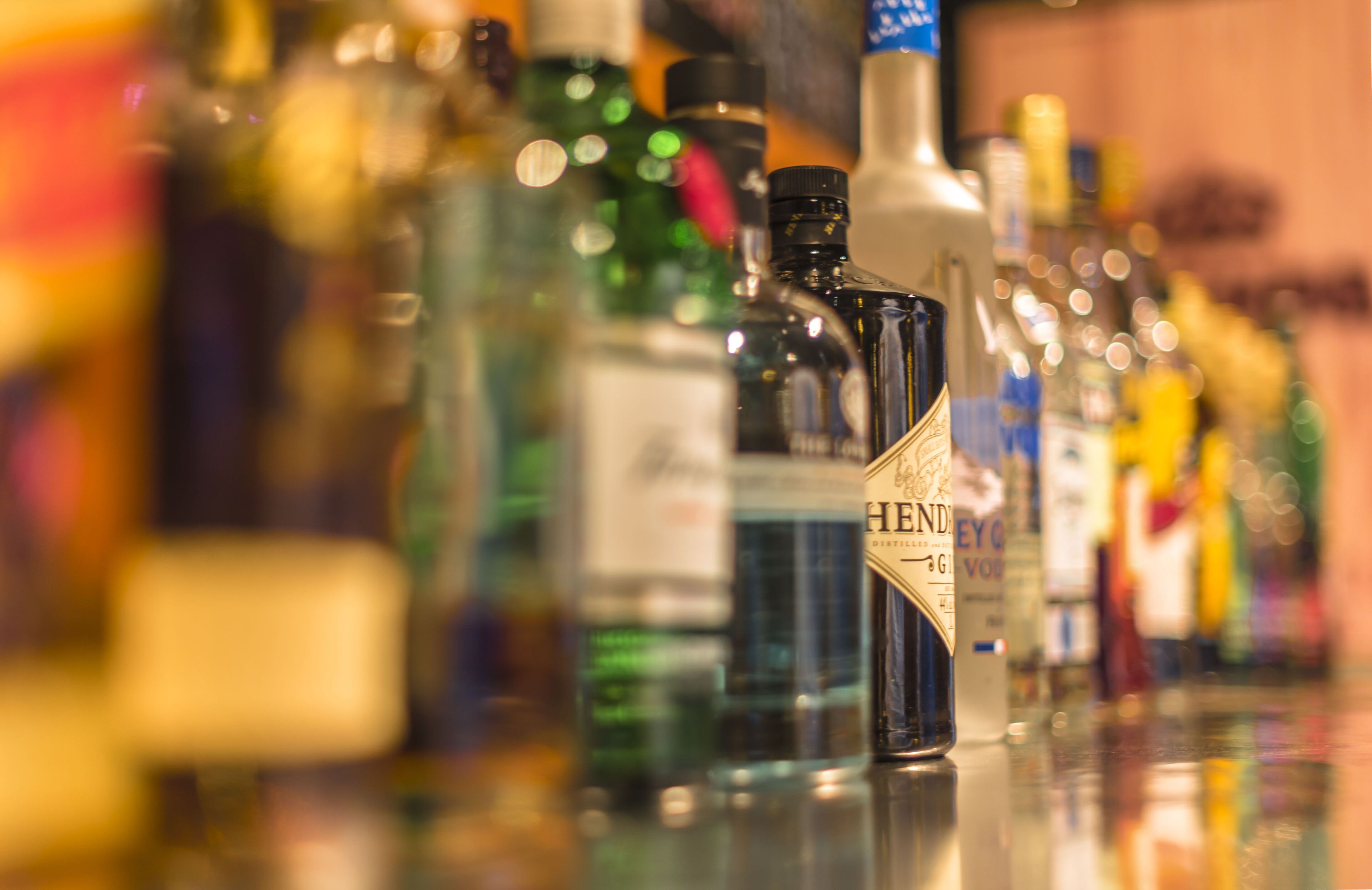 A variety of liquor bottles on a bar counter.