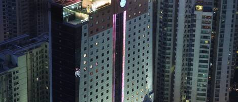 Un edificio alto con techo de estilo tradicional y ventanas iluminadas.
