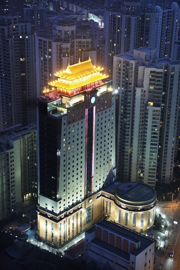Un edificio alto con techo de estilo tradicional y ventanas iluminadas.