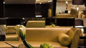 A modern hotel lobby with a glass coffee table, a sofa, and a magazine.