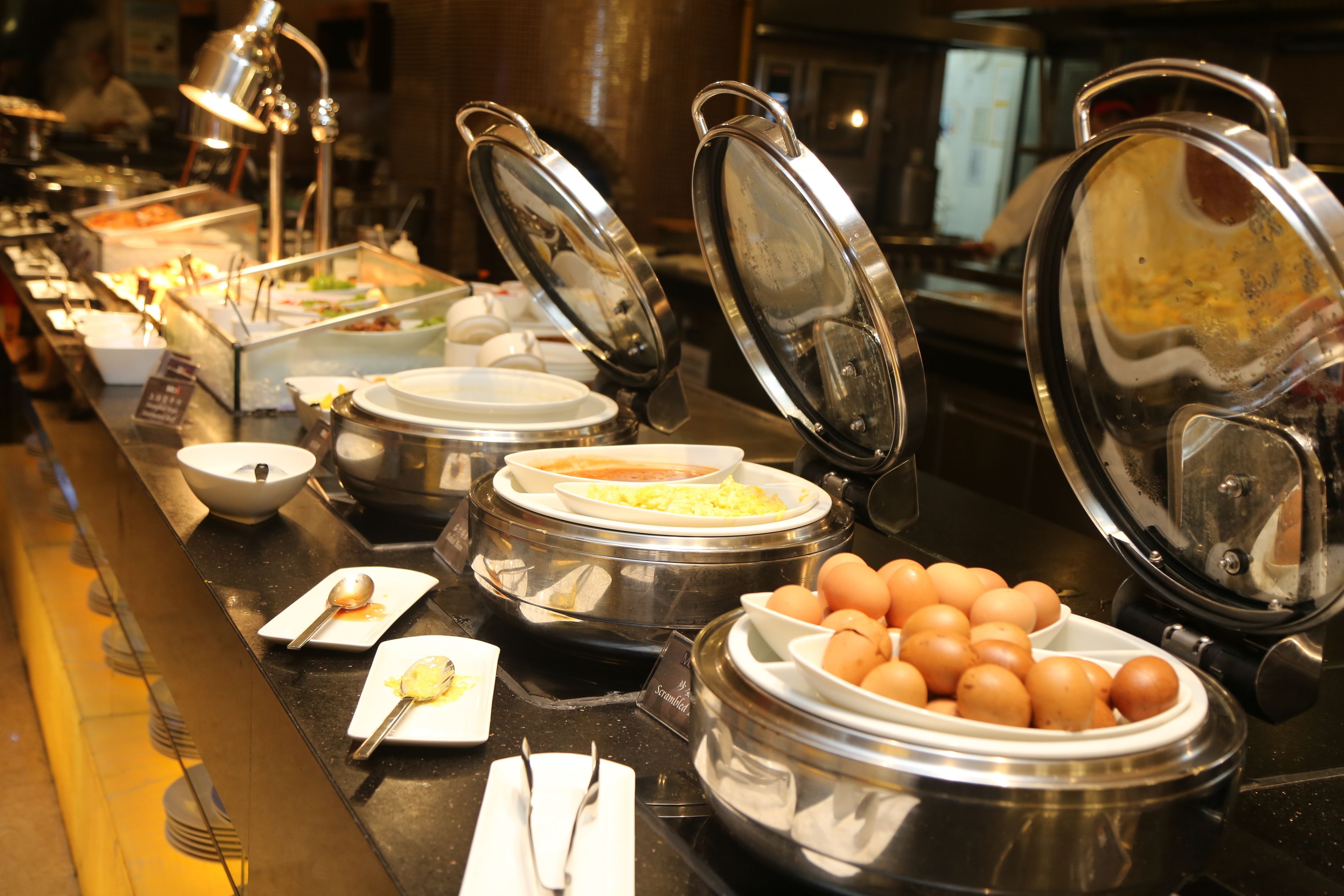 Una mesa de buffet con diversos alimentos y utensilios.