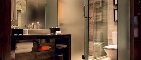 A modern bathroom with a glass shower enclosure, a vanity with a sink, and a toilet.