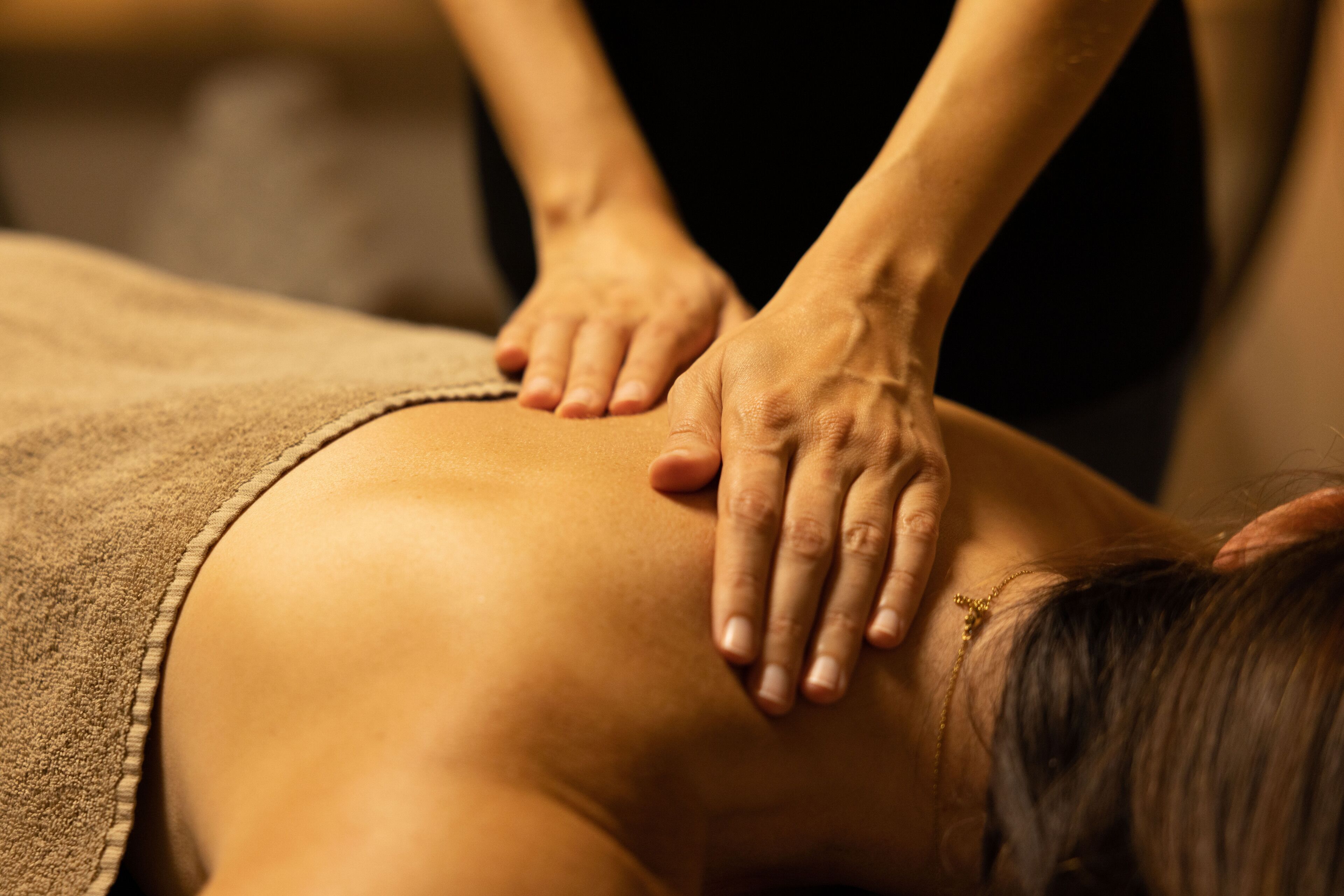 A close-up of a massage being performed on a person's back.