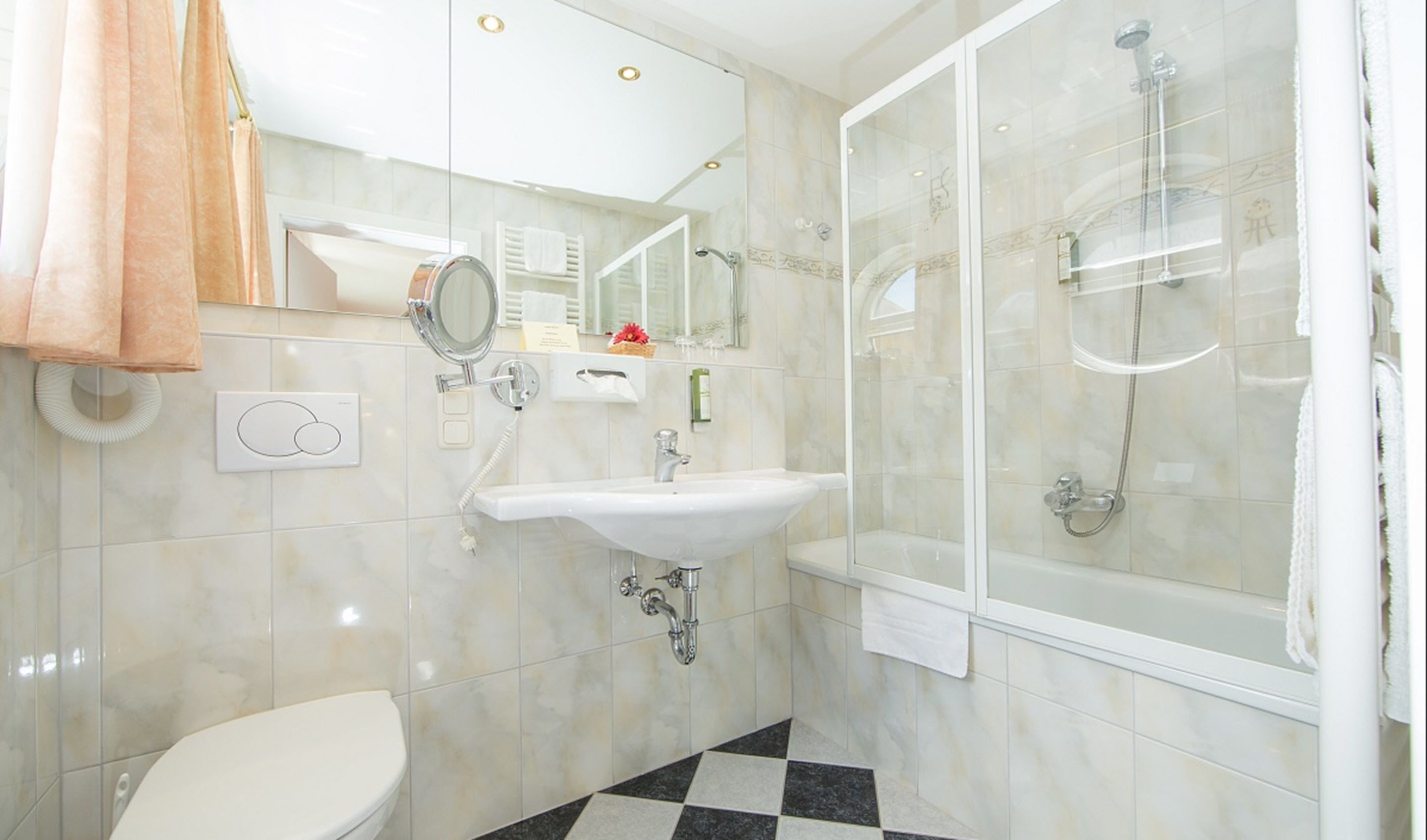 A bathroom with a toilet, sink, and shower.