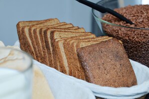 Rebanadas de pan moreno y un tazón de granola de chocolate.
