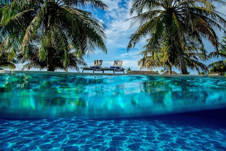 Una piscina al aire libre, sillones reclinables de piscina