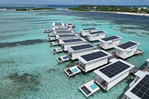 An overwater resort with multiple bungalow-style accommodations, each with a private pool and solar panels. - Holiday Inn Resort Kandooma Maldives by IHG (Kandooma)