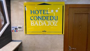 A yellow sign for Hotel Concedu Badajoz with a digital payment machine below it. - Hotel Condedu Badajoz (Badajoz)