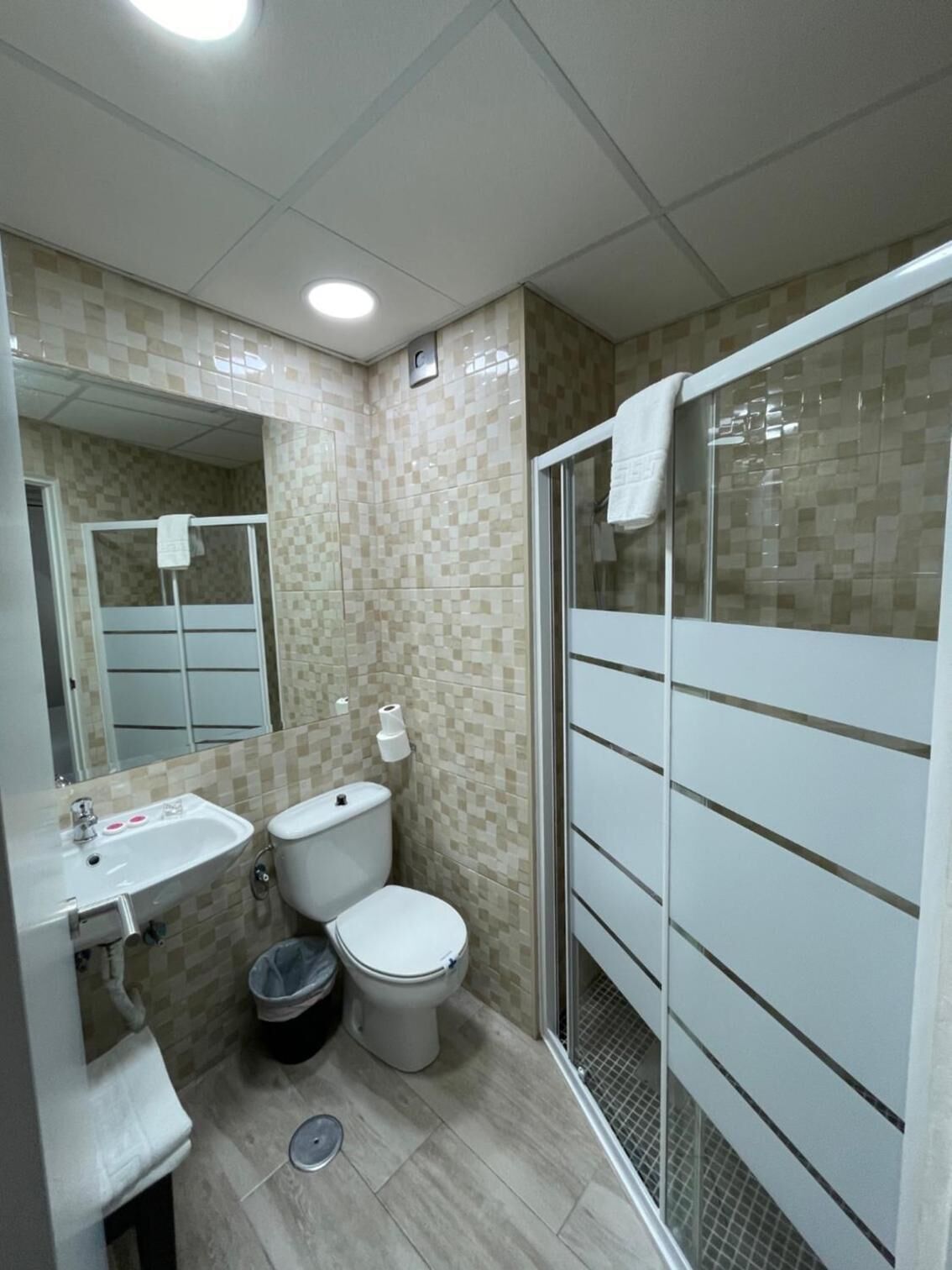 A modern bathroom with a toilet, sink, and shower.