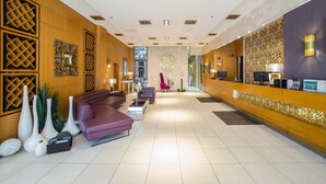 A spacious lobby with a reception desk, seating area, and decorative wall panels. - Marmara Hotel Budapest (Budapest)
