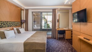A hotel room with a bed, desk, TV, and a view of the outside. - Marmara Hotel Budapest (Budapest)