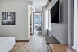 A hotel hallway with a bed, a TV, and a view of a Ferris wheel.