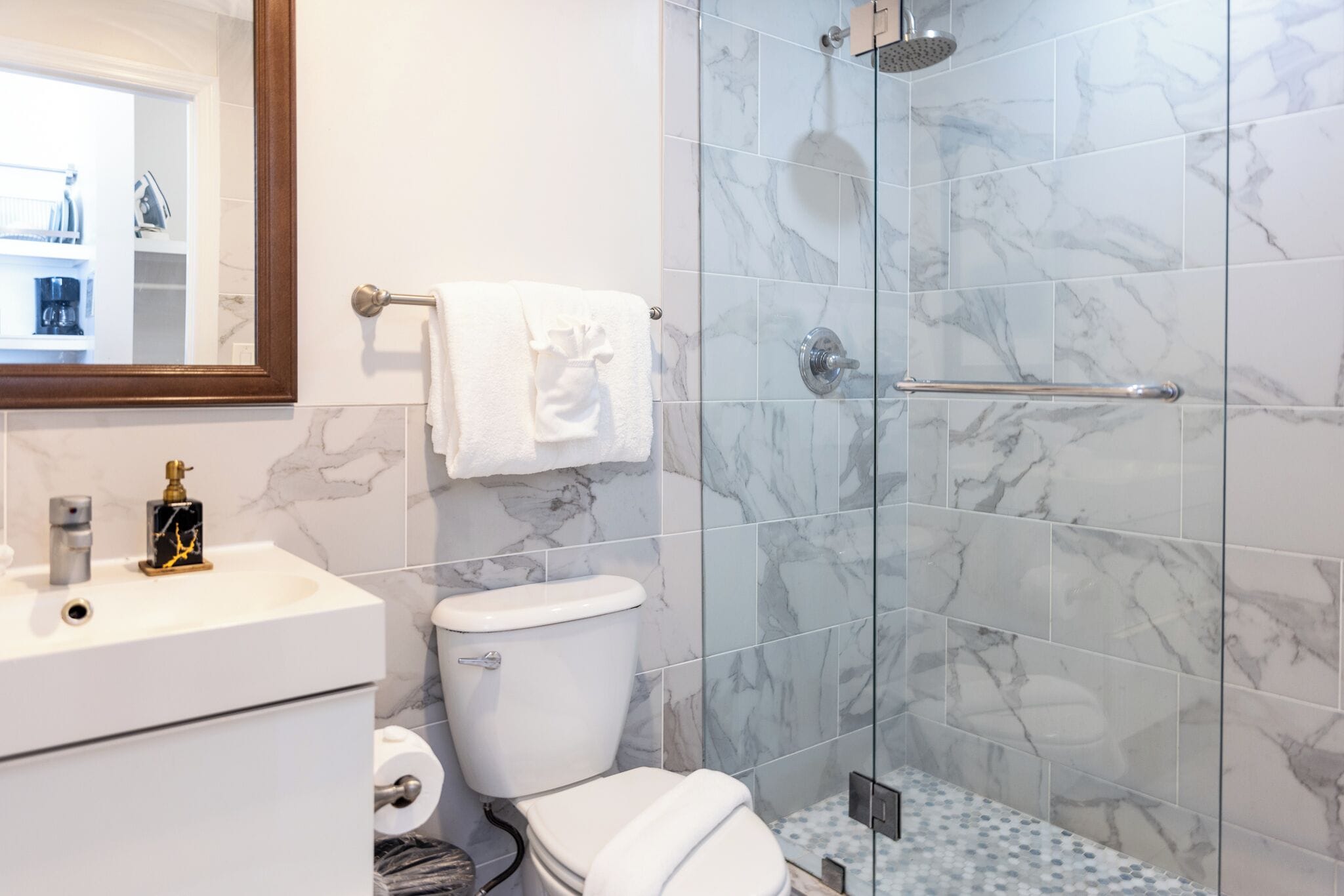 A bathroom with a toilet, sink, and shower.